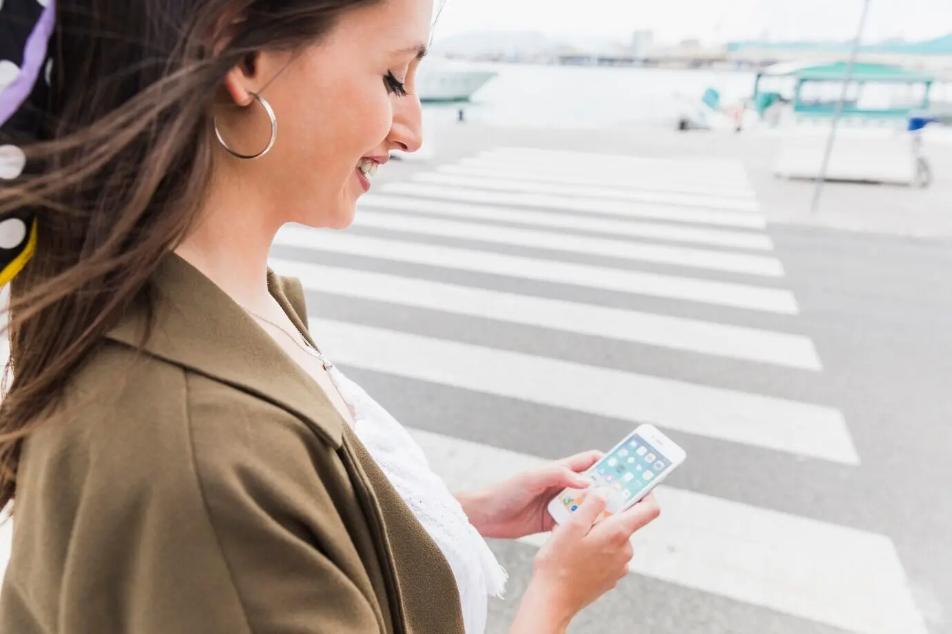 Nahaufnahme einer fröhlichen jungen Frau, die ein Handy hält.