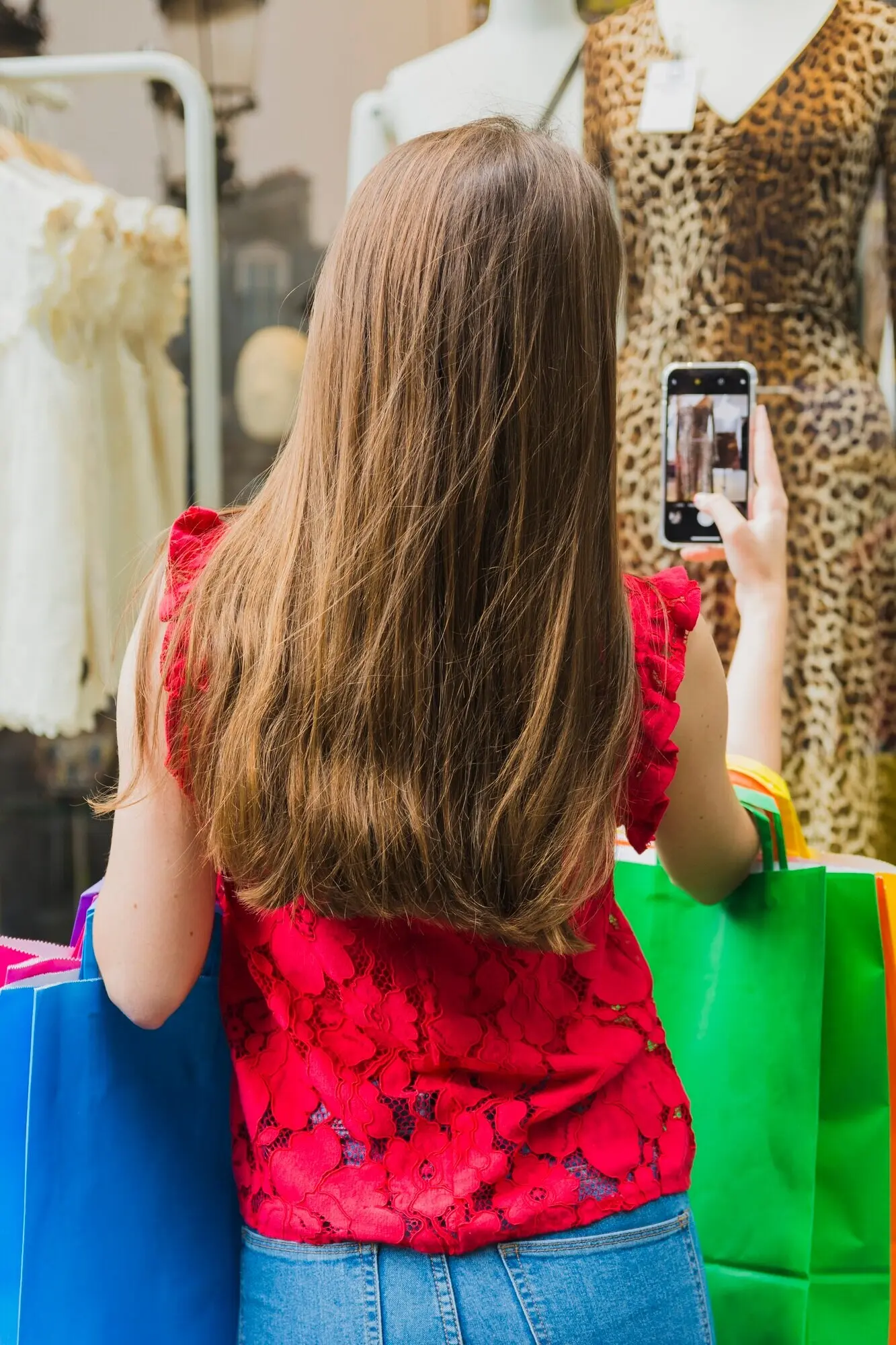 Eine Frau in Rot fotografiert ein Kleid.